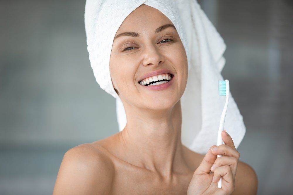 Femme au sourire sain avec une brosse à dents