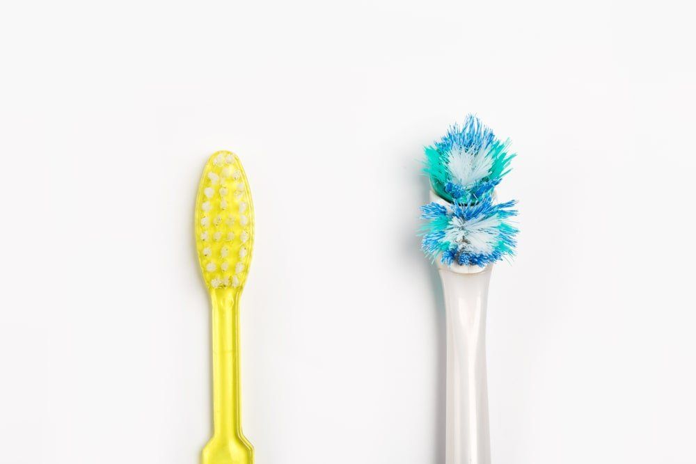 Une brosse à dents neuve et une brosse usée