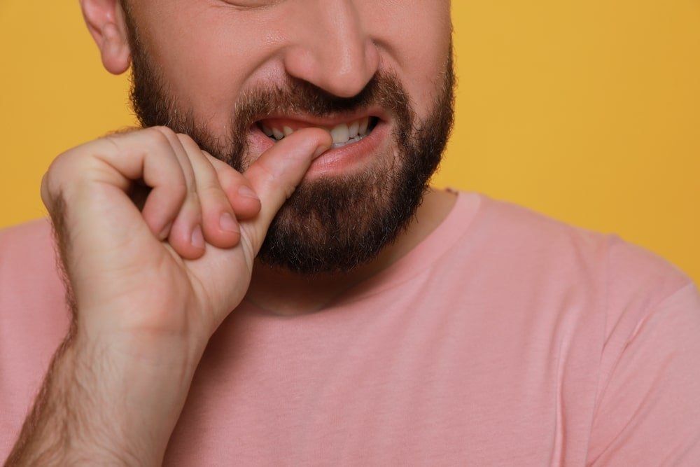 homme qui se ronge les ongles