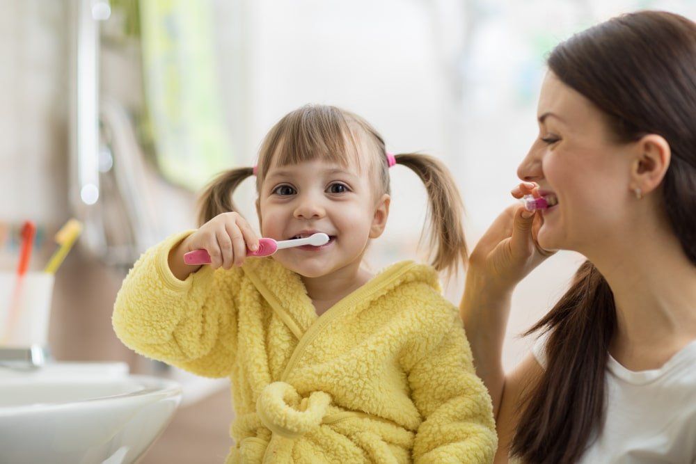 Un mère et sa fille font leur hygiène dentaire
