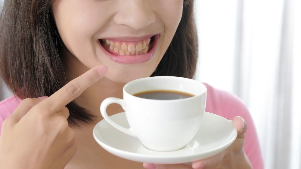 sourire aux dents jaunes et tasse de café