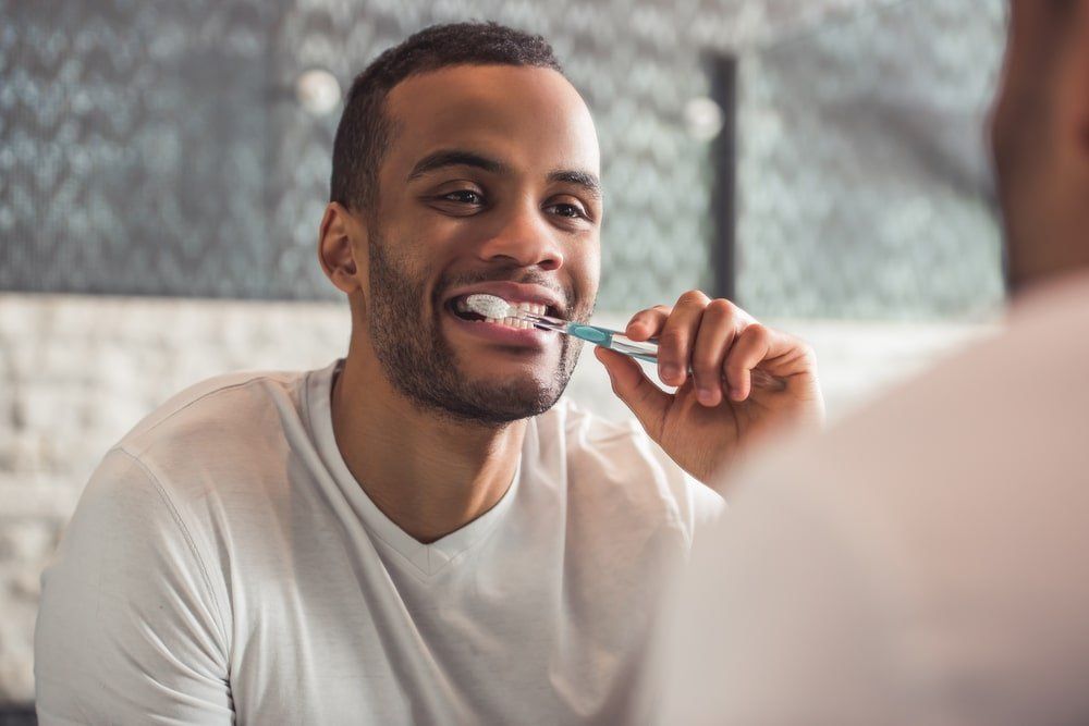 homme lors de son hygiène dentaire quotidienne