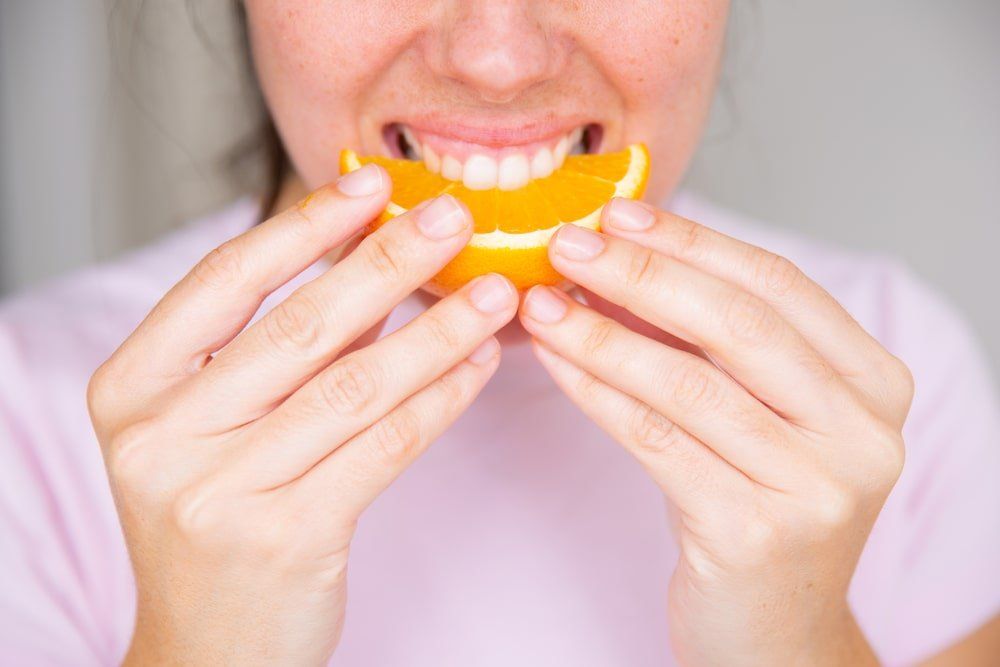 gros plan d'une orange acide et d'une bouche