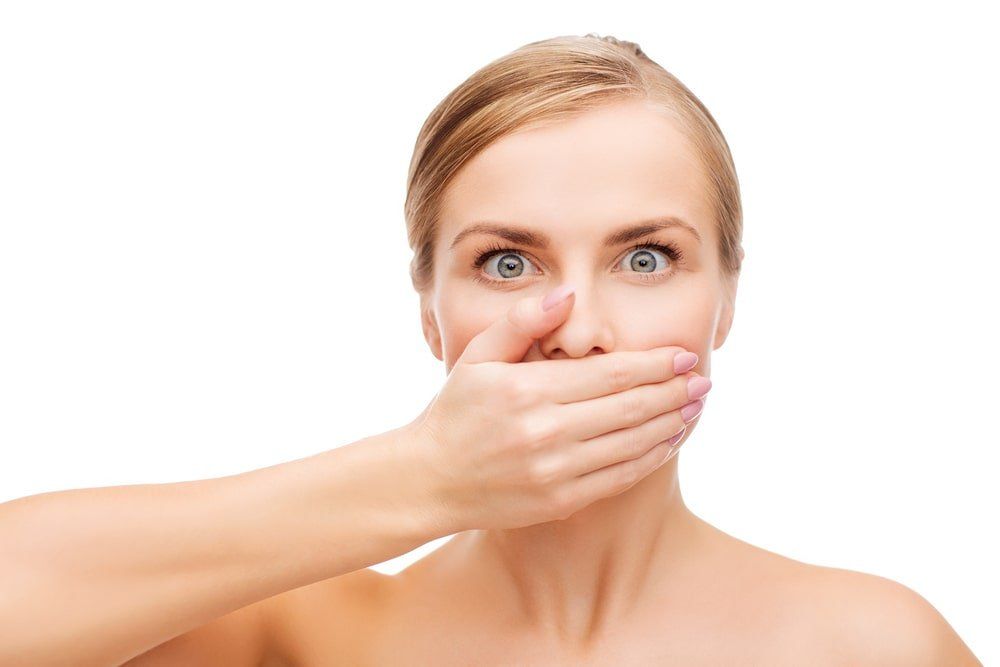 Femme qui cache des signes de mauvaise santé buccodentaire