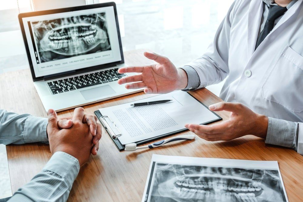 Un dentiste explique un problème dentaire à son patient