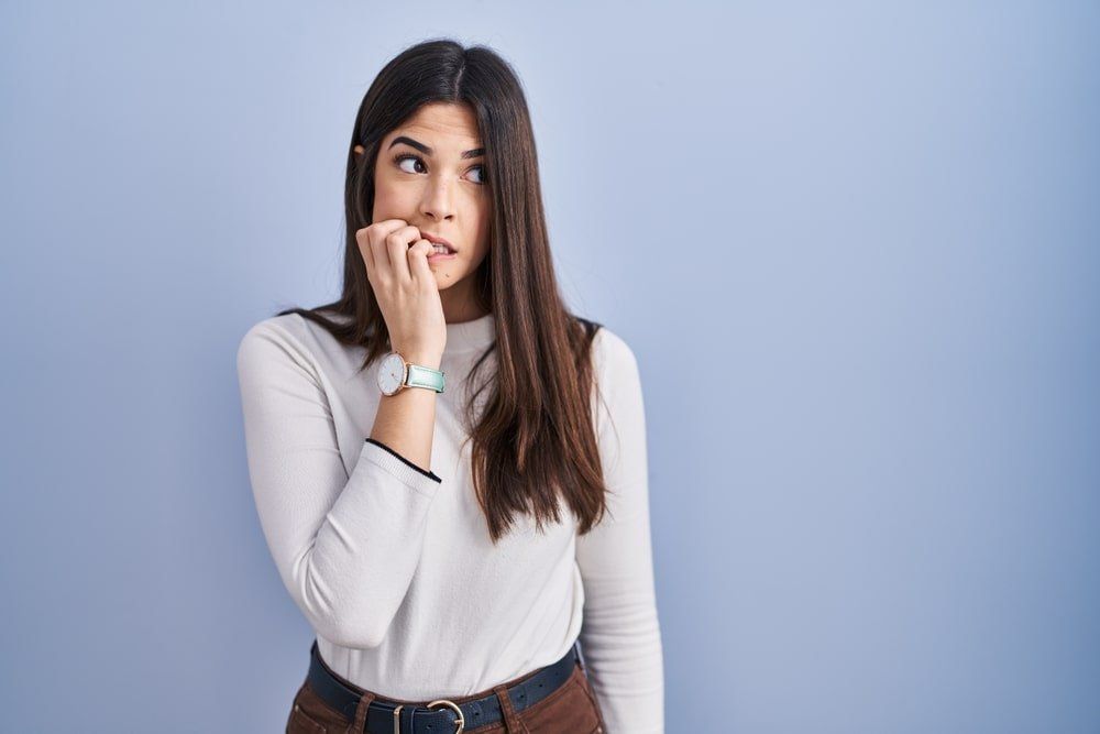 Une jeune femme en train de se ronger les ongles