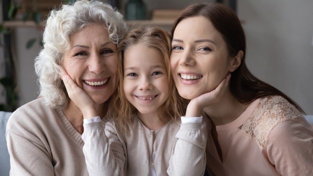 Fillette, mère et grand-mère qui sourient.