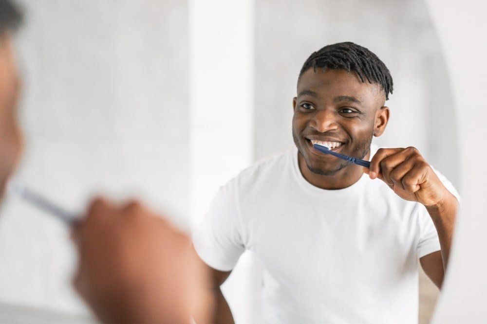 Un jeune homme adopte la bonne technique de brossage des dents